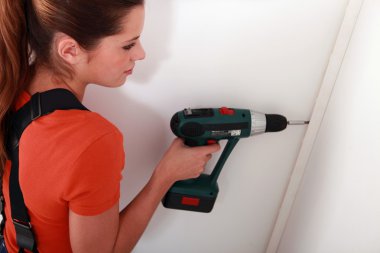 Woman fixing something on a wall clipart