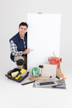 Laborer kneeling by supplies clipart