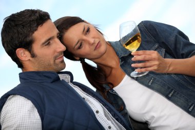 Couple looking at a glass of alcohol clipart