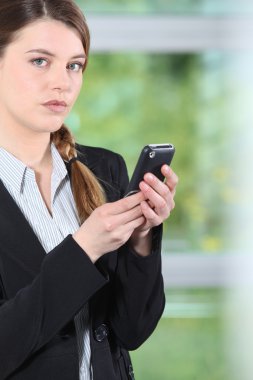 Young businesswoman checking phone. clipart