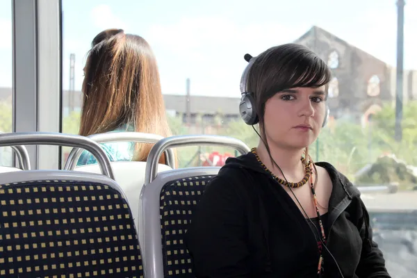 Jovem mulher ouvindo seus fones de ouvido em um bonde — Fotografia de Stock