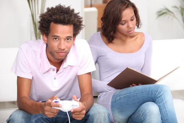 Paar liest und spielt Computerspiele — Stockfoto