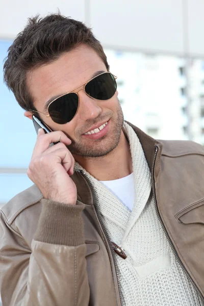 Trendy man with leather jacket on cellphone — Stock Photo, Image