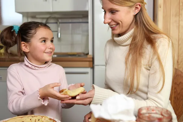 Kleines Mädchen schenkt ihrer Mutter einen Crêpe — Stockfoto