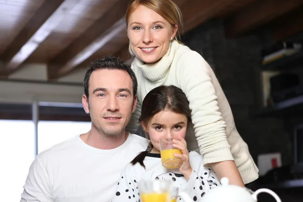Chica joven bebiendo un vaso de jugo de naranja mientras posando para la cámara ingenio —  Fotos de Stock