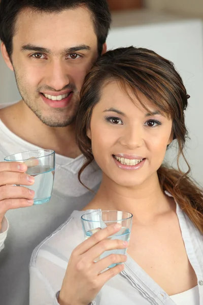 Enthusiastic man and woman with glasses of water — Stock Photo, Image