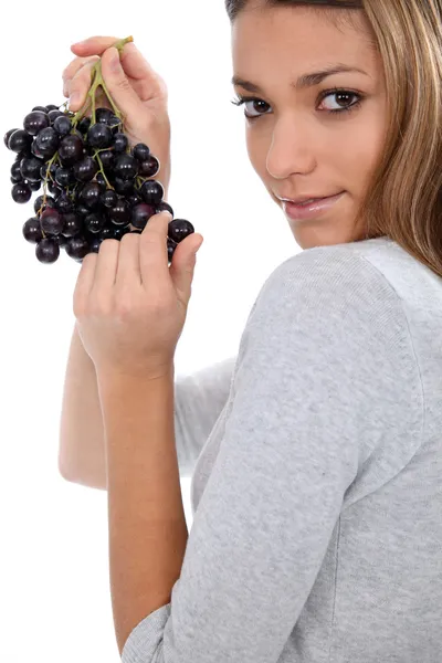 Une jeune femme savourant sensuellement un raisin — Photo