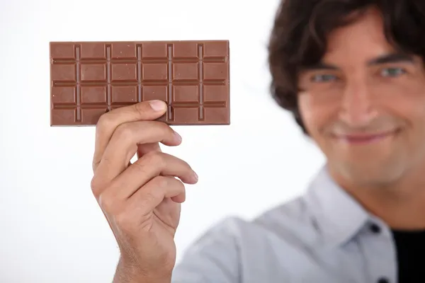 Chico sosteniendo una barra de chocolate — Foto de Stock