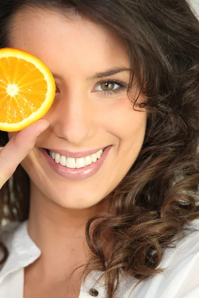 Девушка с кусочком апельсина — стоковое фото