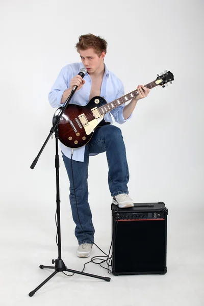 Człowiek gra na gitarze i śpiewa — Zdjęcie stockowe