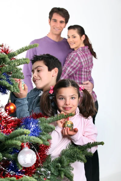 聚集在圣诞树周围的家人 — 图库照片