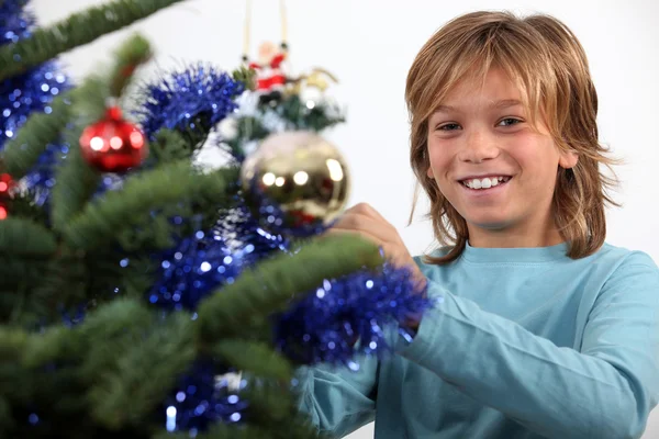 Ler tonårspojke dekorera julgran — Stockfoto