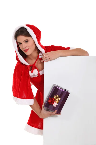 Mademoiselle Santa mignonne avec un cadeau et une planche laissée vide pour votre message — Photo