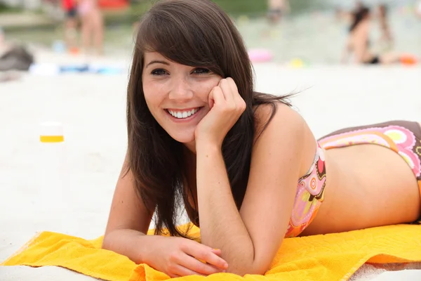 Młoda kobieta leżąca na plaży — Zdjęcie stockowe