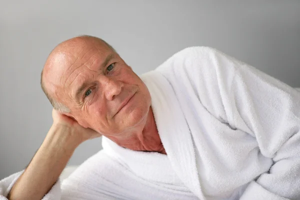 Idős férfi fekszik a fürdőköpeny — Stock Fotó