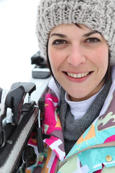 Frau stützt Skier auf Schulter — Stockfoto