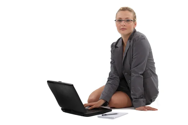 Žena sedí na podlaze a pracuje na svém laptopu — Stock fotografie