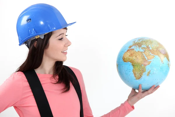Uma trabalhadora de construção feminina segurando um globo . — Fotografia de Stock