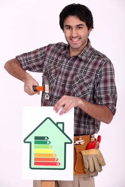 Craftsman nailing an energy consumption label — Stock Photo, Image