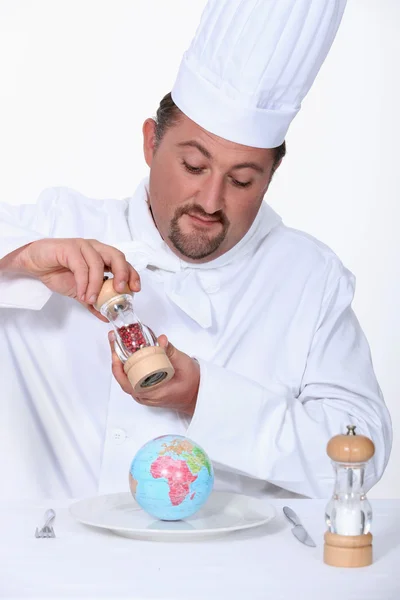 A cook seasoning a globe — Stock Photo, Image