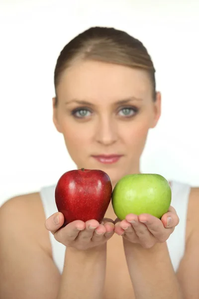 Mulher desfocada mostrando maçãs no fundo branco — Fotografia de Stock
