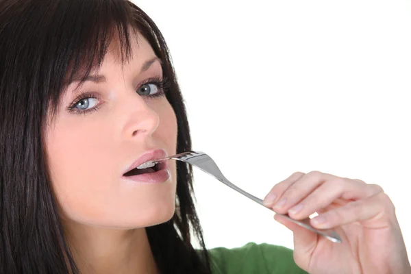 Mujer poniendo tenedor a la boca — Foto de Stock