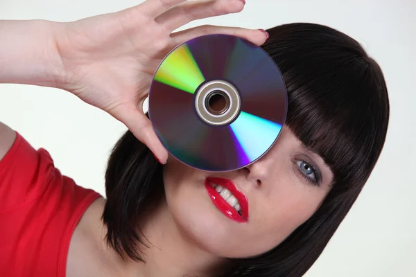 Frau hält eine CD an ihr Auge — Stockfoto