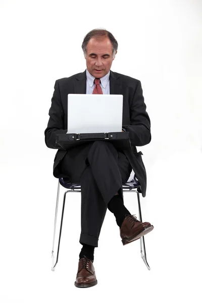 Bir dizüstü bilgisayar kullanarak iş adamı — Stok fotoğraf