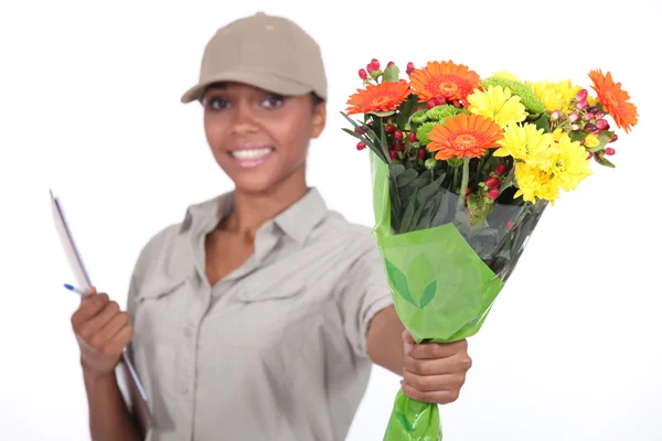 Delivery woman giving flowers — Stock Photo, Image