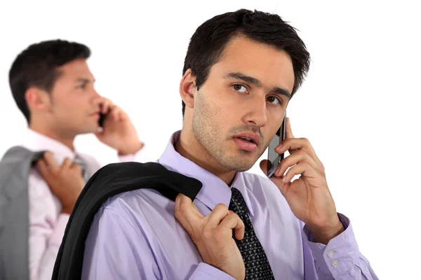Два молодых бизнесмена разговаривают по телефону — стоковое фото