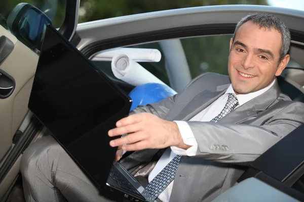 Architect sitting in his car with a laptop — Stock Photo, Image