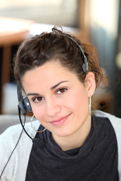 Ung kvinna som bär en telefon headset — Stockfoto