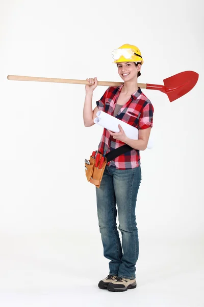 Female construction worker holding plans and spade — Stock Photo, Image