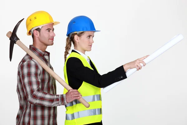 Будівельник стоїть поруч з інженером-будівельником — стокове фото