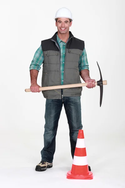 Homme avec pioche et cône de circulation — Photo
