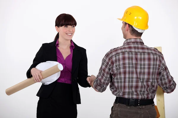Affärskvinna hälsning en byggnadsarbetare — Stockfoto