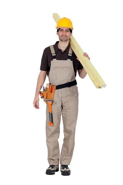 Ein Bauarbeiter trägt Holzbohlen — Stockfoto