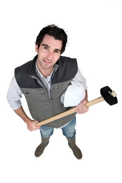 High-angle shot of a tradesman holding a mallet and hard hat — Stock Photo, Image