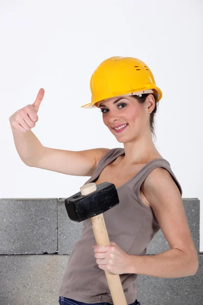 Craftswoman segurando um martelo e fazendo um sinal de polegar para cima — Fotografia de Stock