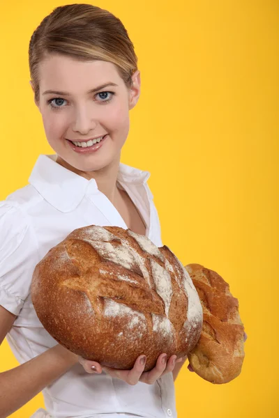Woman holding round loaves of bread — Stock Photo, Image