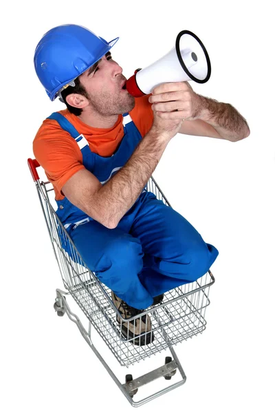 Builder with megaphone sat in trolley — Stock Photo, Image