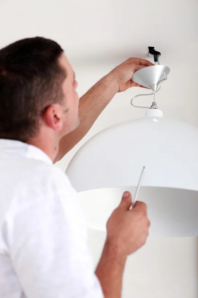 Майстер закріплює лампу на стелі — стокове фото