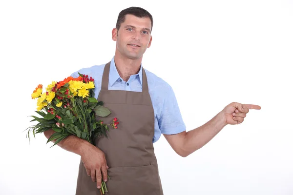 Male florist pointing out of shot — Stock Photo, Image