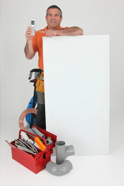 stock image Plumber with mobile stood by poster