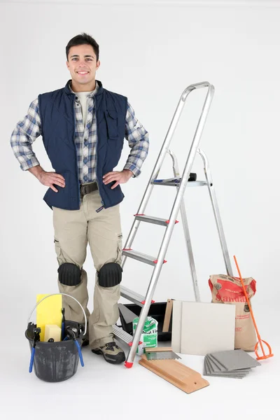 Orgulloso tiler posando cerca de escalera y herramientas — Foto de Stock