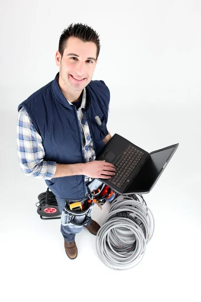 Eletricista com um laptop em branco — Fotografia de Stock