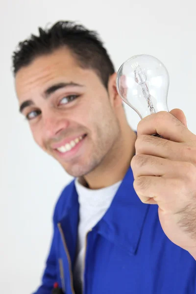 Улыбающийся рабочий держит лампочку — стоковое фото