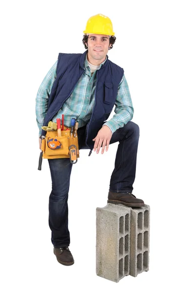 Homem descansando pé no bloco de construção — Fotografia de Stock