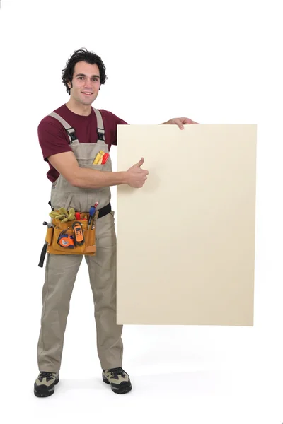 Craftsman holding an empty poster — Stock Photo, Image