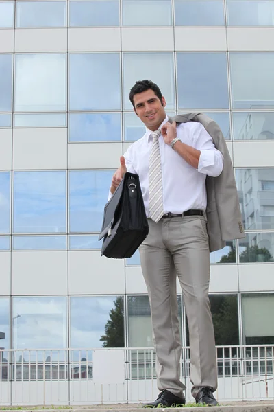 Бизнесмен снаружи стеклянное здание держит сумку — стоковое фото